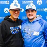 Two Laker and Lions fans pose for a photo at the backdrop